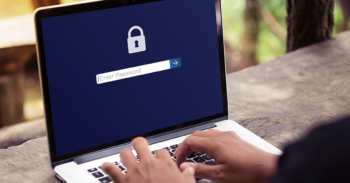 Man types on locked laptop